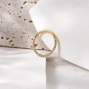 Macro shot of 16G golden titanium clicker ring with sparkling zircon stones