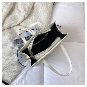 Top view of white fashion crossbody bag interior showing multiple compartments and strap