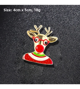 Macro detail of Christmas reindeer brooch with red enamel and Merry Christmas text