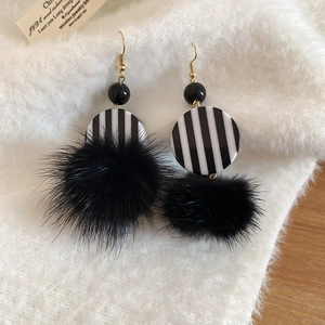 Detail of vintage striped resin disc and large black pompom on these fashion drop earrings