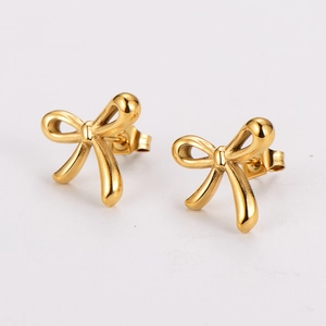 Close-up of polished gold bow stud earrings with minimalist elegant knot design