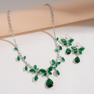 Close-up of green rhinestone butterfly necklace and earring set with silver base