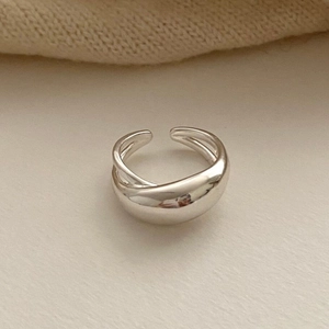 Minimalist silver cross geometric open ring with polished metal finish on beige surface