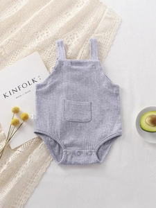 Gray ribbed knit infant romper with suspenders and pocket on a cozy lifestyle background