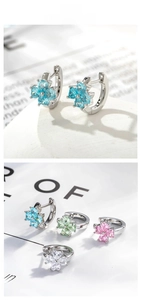Detail of flower hoop earrings with blue and multi-colored zircon stones on a magazine