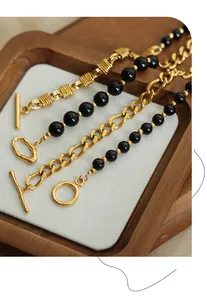 Detail of four gold twist chain bracelets with black agate beads and OT toggles