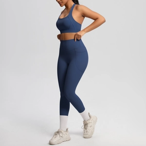 Close-up of dark blue high-waist yoga leggings with a side pocket and matching sports bra