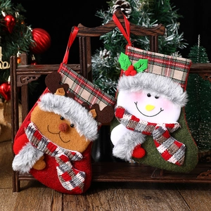 Festive Christmas stockings with plush reindeer and snowman figurines hanging by tree