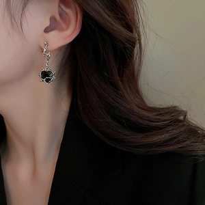 Macro shot of gothic thorn heart earrings with red crystal on a female model