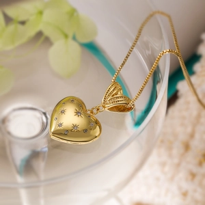 Macro shot of 18K gold heart pendant with star-set cubic zirconia on box chain necklace