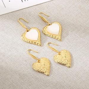 Classic stainless steel heart earrings set with white cat eye stones in gold finish