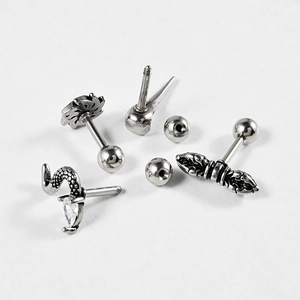 Detailed view of silver stainless steel ear studs with snake and punk style motifs