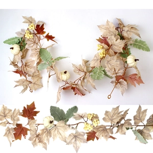Close-up of autumn garland featuring white pumpkins, maple leaves, and yellow berries