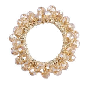 Close-up of champagne crystal bead hair tie with woven golden elastic band detail