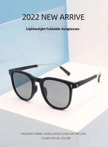 Makro-Detail einer faltbaren schwarzen Sonnenbrille mit silbernen Metallbügeln auf Geometrie