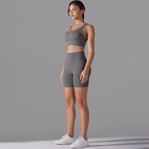 Vista laterale del set fitness grigio con pantaloncini a vita alta e reggiseno