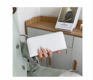 Detail of white lychee pattern long wallet held by a model in a sage green suit
