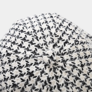 Close-up of classic black and white houndstooth pattern fabric on a beret hat