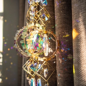 Suncatcher with natural stones and crystal prisms creating rainbows on dark backdrop