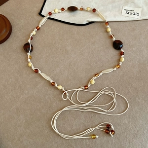 Detail of bohemian handmade beaded waist chain with acrylic resin beads and cotton tassels
