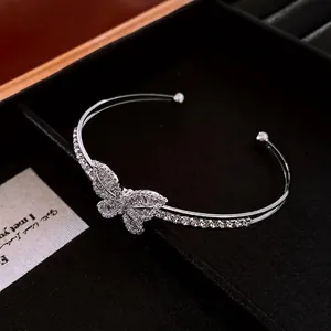 Silver open cuff bangle with butterfly zircon inlay on a black jewelry tray