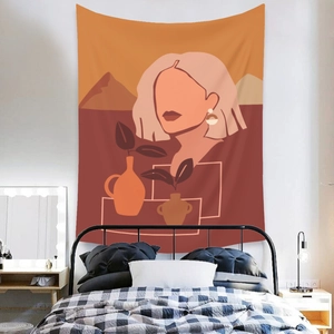 Detail of bohemian tapestry featuring abstract female portrait and warm orange tones