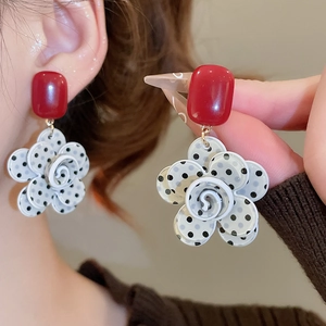 Detailed macro view of vintage resin flower tassel earrings on model showing textures