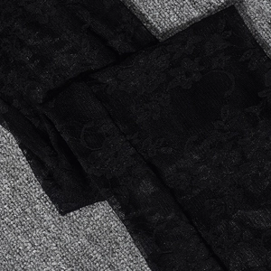 Close-up of black floral lace fabric details and fine mesh on backless jumpsuit