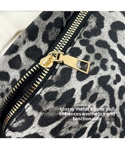 Macro detail of leopard print fabric with a polished gold-tone metal zipper slider