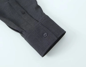Détail du poignet d'une chemise gris anthracite avec coutures et bouton assortis