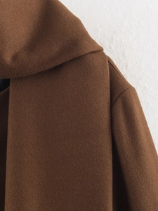 Detailed macro shot of the brown wool coat featuring thick texture and shoulder seam details