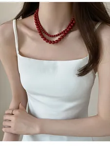 Détail d'un collier à double rang de perles rouges de style vintage français sur mannequin