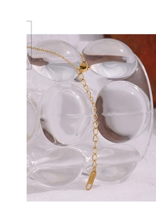 Macro view of gold stainless steel necklace chain detail with lobster clasp and extension