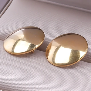 Macro shot of minimalist gold polished chunky oval stud earrings on a jewelry box