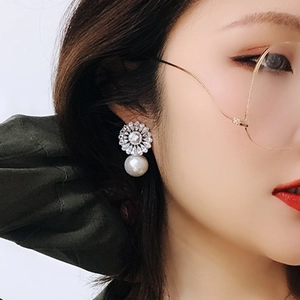 Baroque flower earrings with zircon stones and pearls shown on a model in a high-quality view