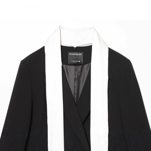 Blazer femme chic bicolore noir et blanc avec col écharpe et coupe ajustée