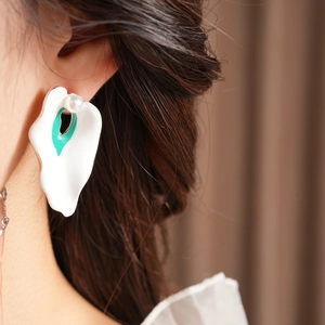 Close-up of vintage enamel petal earrings with green accents and pearls on a model