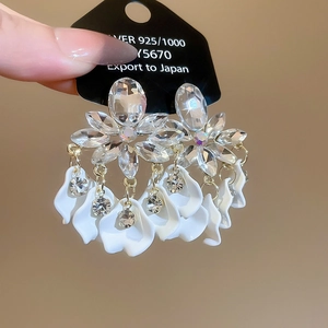 Close-up of vintage rhinestone leaf earrings with long tassels and 925 silver stamp