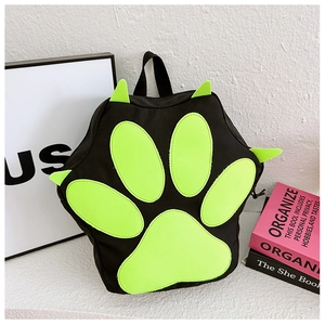 Detail view of cartoon cat paw backpack with green claws and paws on black canvas material