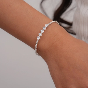 Detailed view of a silver link bracelet featuring five stacked square-cut zircon stones