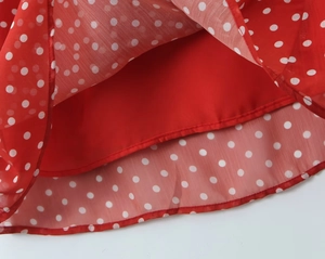 Detail des roten Polka-Dot-Kleidsaums mit atmungsaktivem Chiffon und glattem Innenfutter