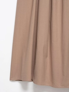 Close-up detail of khaki woven fabric dress showing neat hemline and textured material