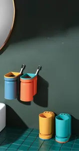 Detail of four colorful bathroom cups with wall-mounted bases for family organization