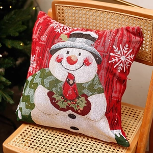 Cozy snowman Christmas throw pillow on a vintage wooden chair with festive lights