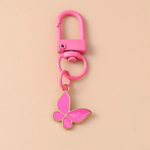 Detailed close-up of a pink enamel butterfly keychain with elegant gold-plated metal edges