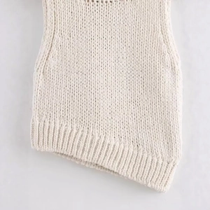 Off-white knit top featuring unique asymmetric hem and textured ribbed fabric finish