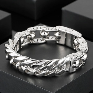 Makroaufnahme: Silbernes Edelstahl-Panzerarmband mit Kugeldetails auf schwarzer Box