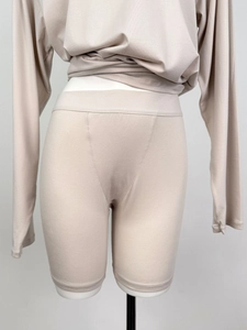 Detail of beige long-sleeve knit lounge top and fitted biker shorts set for women