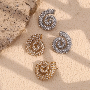 Detail of 18K gold and silver conch earrings with pavé crystals and white pearls