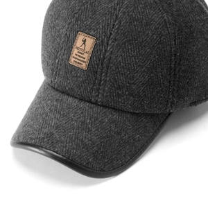 Detailed view of dark grey herringbone texture and leather golf patch on winter cap